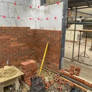 Professional bricklayer constructing an outer cavity wall with thermal insulation in Hull.