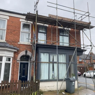 Front view of a Victorian terraced home in Hull with full safety scaffolding setup for roof work.