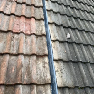 Close-up of interlocking concrete roof tiles fitted neatly against a central weather trough.