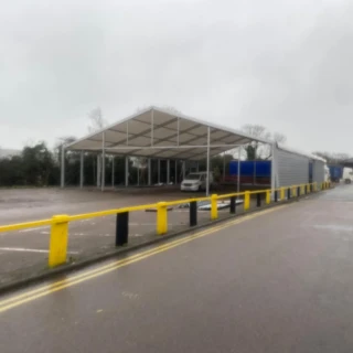 Wide outdoor shot of a temporary industrial shelter constructed next to a commercial unit in Hull.