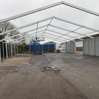 Open steel portal frame structure erected on tarmac surface for commercial project in Hull.
