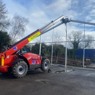 Manitou telehandler placing steel beams into position for commercial canopy construction.